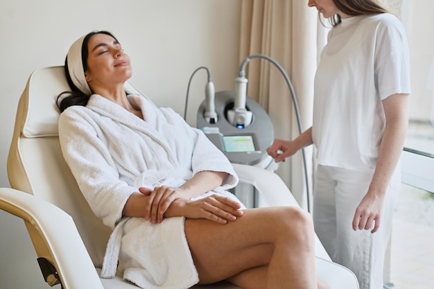 Hermosa mujer disfruta de un masaje de glúteos con una máquina de endoesfera para la corrección anticelulítica y corporal