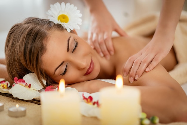 Foto hermosa mujer disfrutando durante un masaje de hombros en un spa.