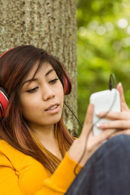 Hermosa mujer disfrutando de la música en el parque