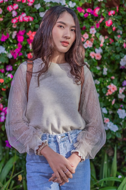 Hermosa mujer disfrutando del paisaje. Visita las flores en la granja de Jim Thompson.