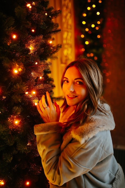 Hermosa mujer disfrutando de las vacaciones de invierno en el mercado de Navidad Luces alrededor