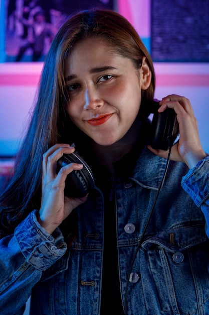 Hermosa mujer Dj alegre disfrutando de escuchar musica por sus auriculares mientras mezcla musica