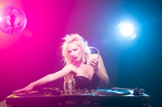 Hermosa mujer dj con pila de discos de vinilo