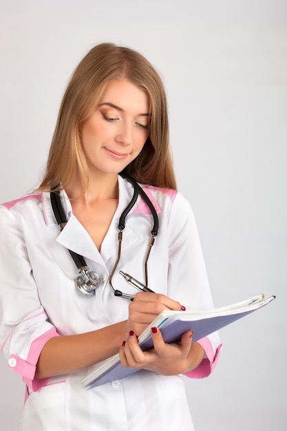 Hermosa mujer doctora con un estetoscopio y un diario xA para notas