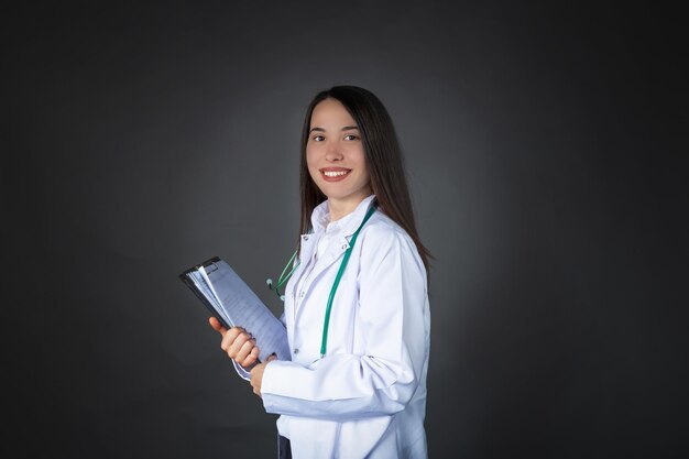 Hermosa mujer doctora turca sonriente con un archivo de paciente en sus manos