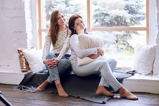 Hermosa mujer e hija en el sofá