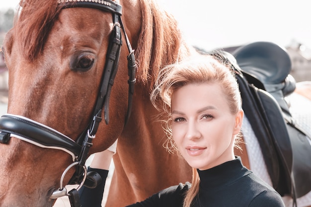 Hermosa mujer elegante caminando con un caballo en un club de campo. Deporte ecuestre, alquiler de caballos, concepto de ocio. Técnica mixta