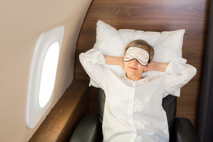 Hermosa mujer elegante durmiendo en una cabina de jet privado sobre una almohada