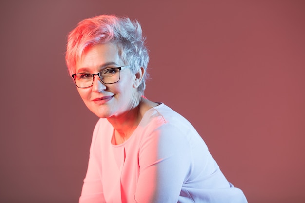 hermosa mujer elegante en edad, con gafas con un corte de pelo corto