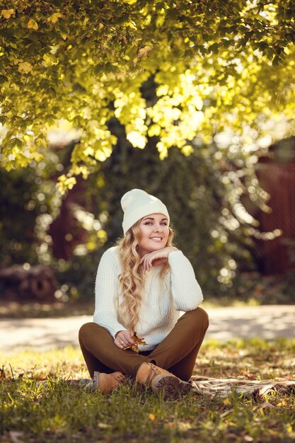 Hermosa mujer elegante de pie en un parque en otoño.