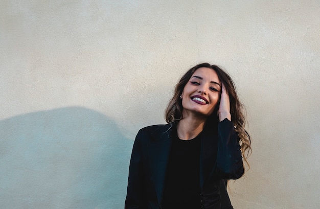 Hermosa mujer elegante. Retrato de mujer sonriente toca su cabello.