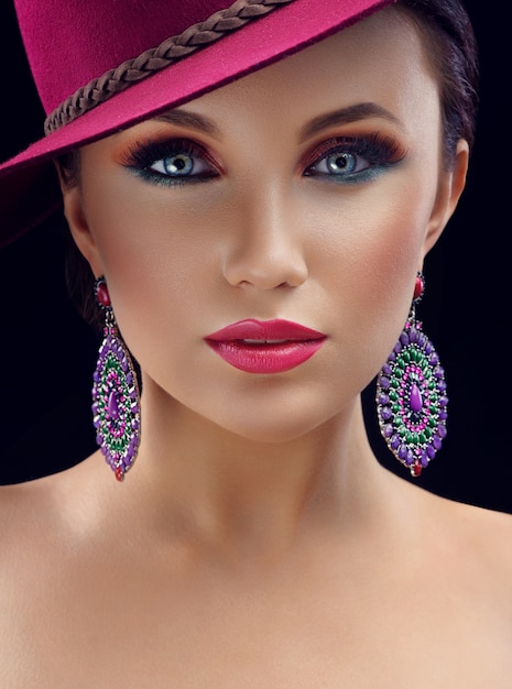 Hermosa mujer elegante con un sombrero posando en estudio