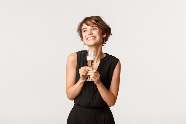 Foto hermosa mujer elegante sonriendo y sosteniendo una copa de champán