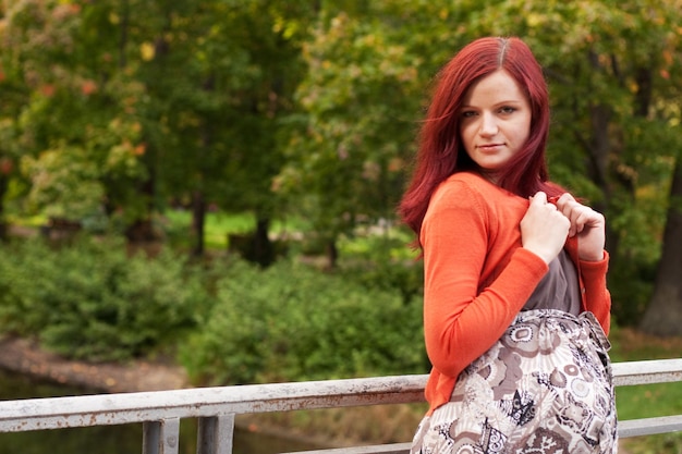 Hermosa mujer embarazada caminando en el parque de otoño