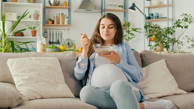 Hermosa Mujer Embarazada Comiendo Desayuno Saludable Muesli Con Nueces En El Sofá