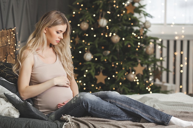 Hermosa mujer embarazada con decoración navideña