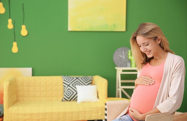 Hermosa mujer embarazada en la habitación de un niño moderno