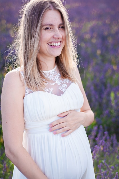 Hermosa mujer embarazada sonriente en el campo