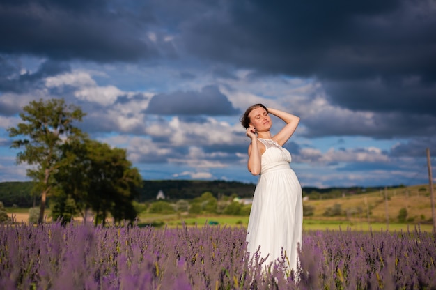 Hermosa mujer embarazada sonriente en el campo