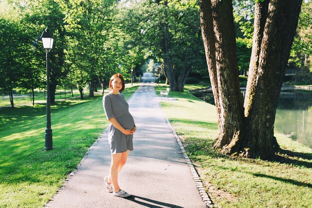 Foto hermosa mujer embarazada en vestido en la naturaleza al aire libre con espacio de copia