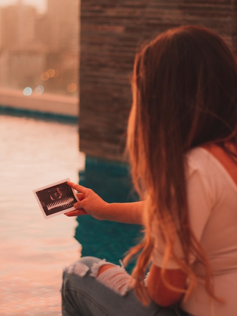 Foto hermosa mujer embarazada viendo el eco de su bebé