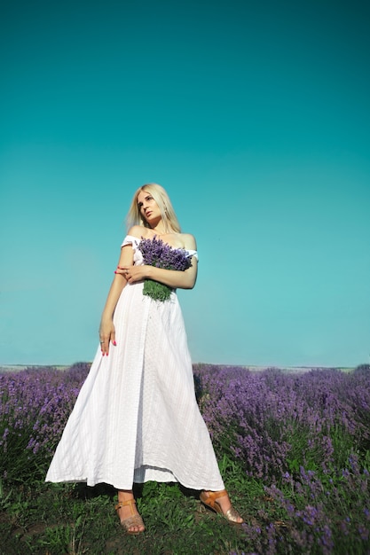 Hermosa mujer se encuentra en la pradera de lavanda.