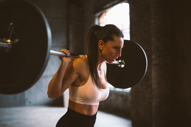 Hermosa mujer entrenando y haciendo ejercicio funcional en el gimnasio