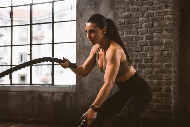 Hermosa mujer entrenando y haciendo ejercicio funcional en el gimnasio