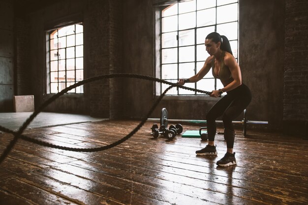 Hermosa mujer entrenando y haciendo ejercicio funcional en el gimnasio