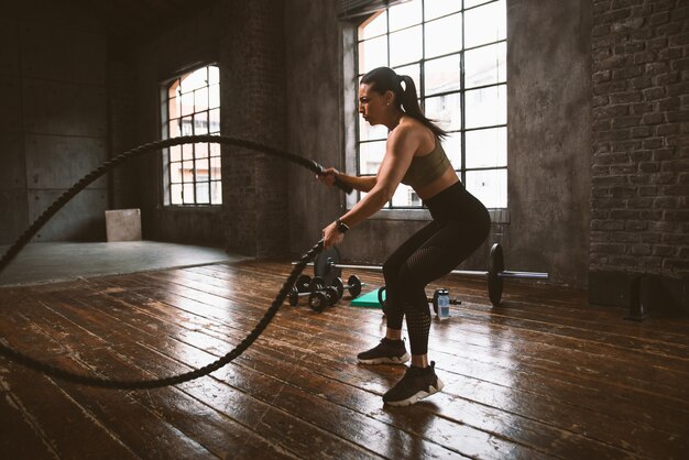 Hermosa mujer entrenando y haciendo ejercicio funcional en el gimnasio