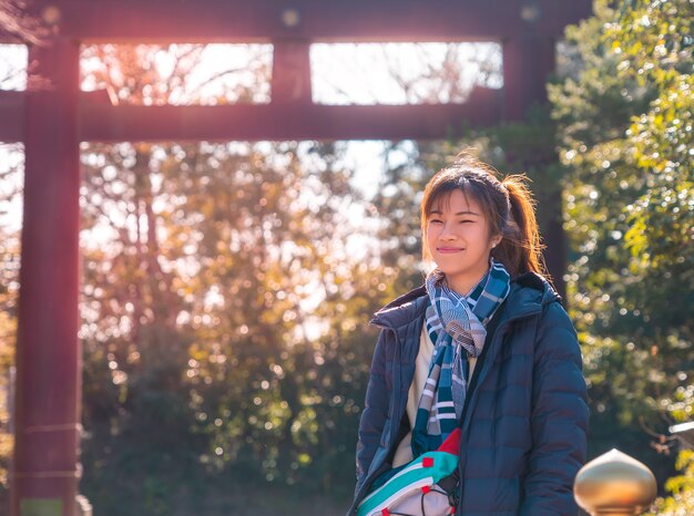 Hermosa mujer es retrato en ropa de invierno en el santuario del templo japonés