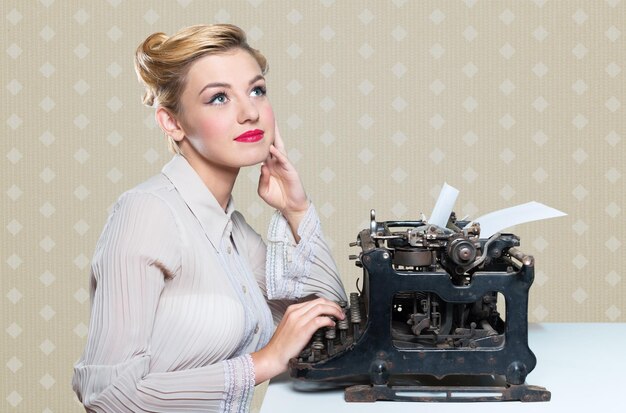 hermosa mujer escribe con una máquina de escribir