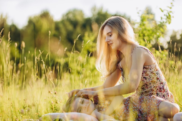 Hermosa mujer está abrazando a su adorable bebé Padre feliz pasando tiempo jugando con su hija en el parque al atardecer Día del bebé de la madre Concepto de familia enfoque selectivo