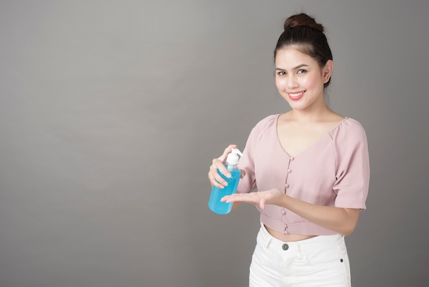 Hermosa mujer está usando gel de alcohol en estudio