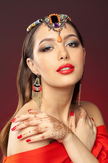 Hermosa mujer en estilo oriental con mehendi en oscuridad