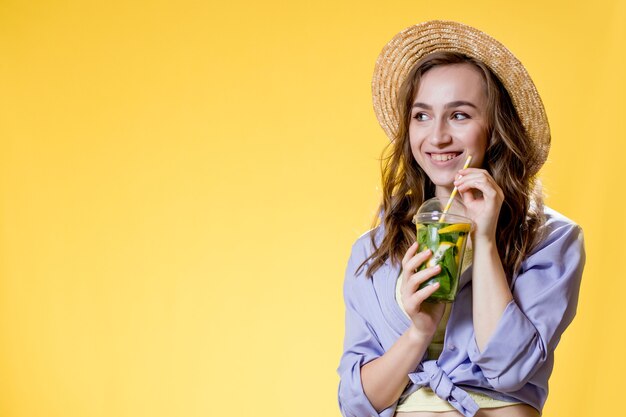 Hermosa mujer expresiva posando con un vaso de bebida