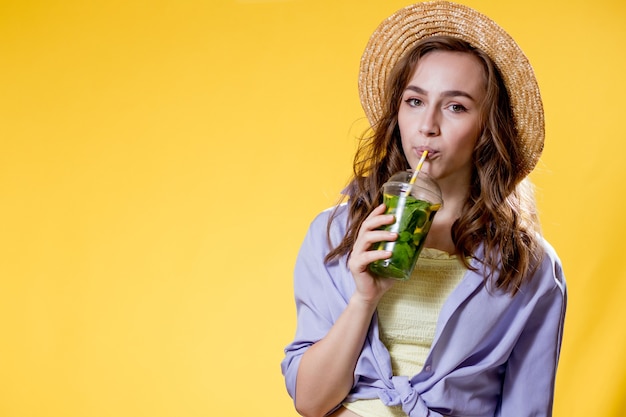 Hermosa mujer expresiva posando con un vaso de bebida