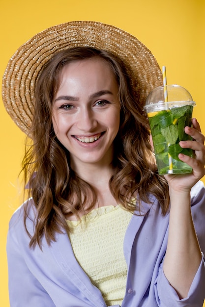 Hermosa mujer expresiva posando con un vaso de bebida