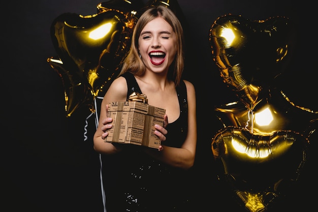 Hermosa mujer feliz con caja de regalo en la fiesta de celebración. Concepto de celebración de cumpleaños o año nuevo.