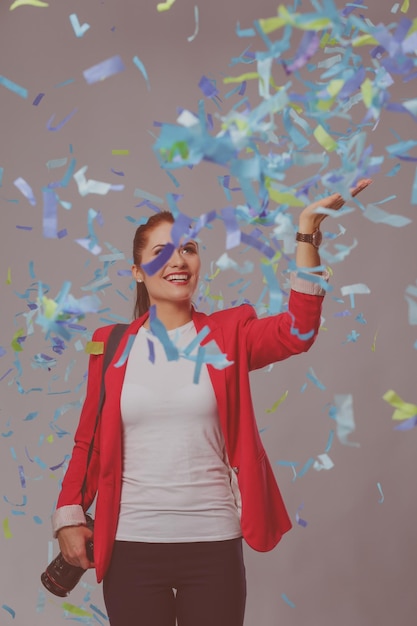 Hermosa mujer feliz con cámara en la fiesta de celebración con confeti Cumpleaños o concepto de celebración de Nochevieja