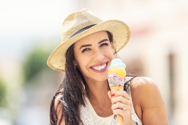 Hermosa mujer feliz lame helado durante un caluroso día de verano