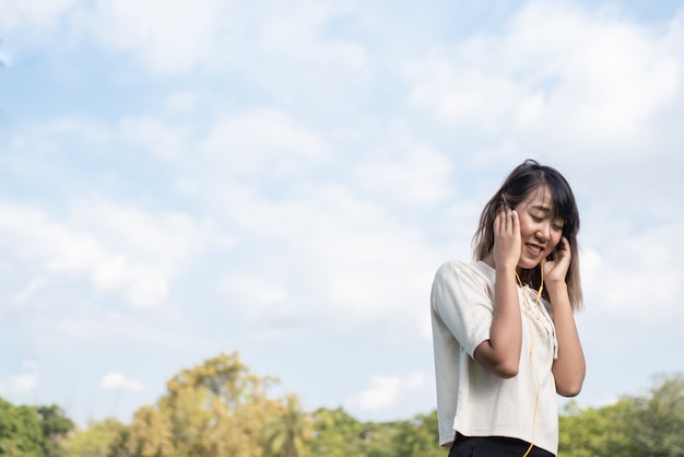 Hermosa mujer feliz se pone auriculares amarillos