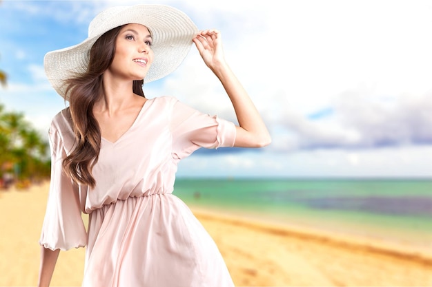 Hermosa mujer feliz con sombrero en la pradera de verano