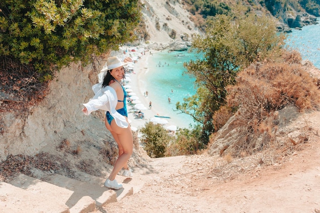 Hermosa mujer feliz yendo a la playa del mar