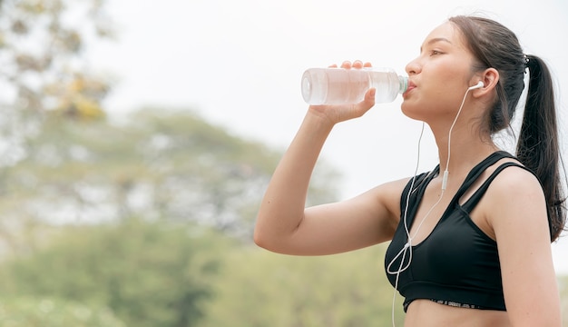 Hermosa mujer fitness agua potable después de hacer ejercicio.