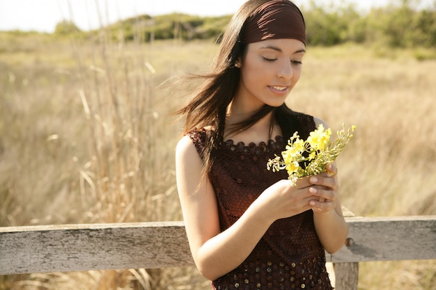 Hermosa mujer en flor dorada al aire libre, amarilla