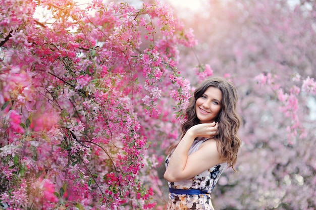 Hermosa mujer en el floreciente jardín de primavera