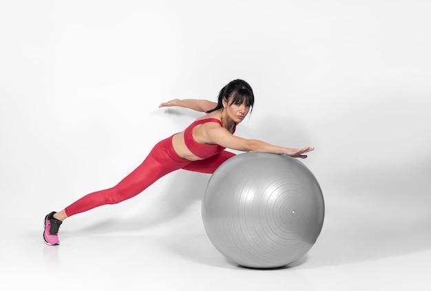 Foto hermosa mujer en forma en el medio 40 haciendo ejercicios con una foto de estudio de pelota de pilates