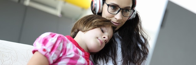 Hermosa mujer en gafas y auriculares trabaja para portátil.