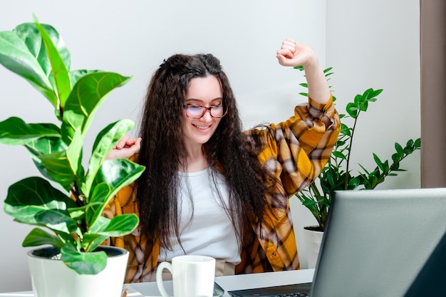 Foto hermosa mujer con gafas bailando con alegría en el lugar de trabajo